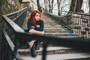 Lonely sad girl sitting on steps